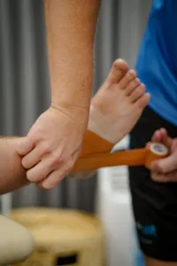 A physio taping an akle injury