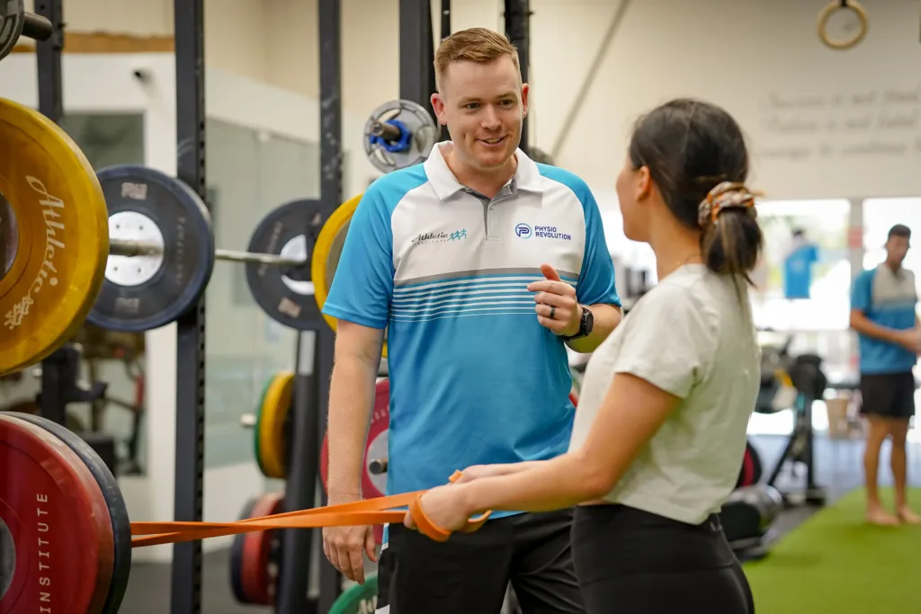 Physiotherapist Matt Beavis, assisting a gym goer.